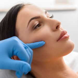 Professional cosmetic surgeon examining facial features
